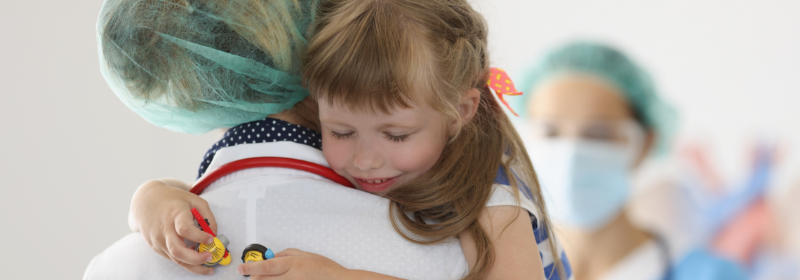 Abbildung eine Fachkinderkrankenpflegerin hält ein Kind auf dem Arm