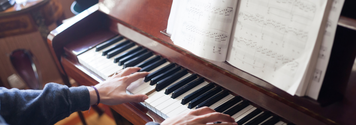 Abbildung eine Person spielt Klavier und vor ihr liegen Musiknoten