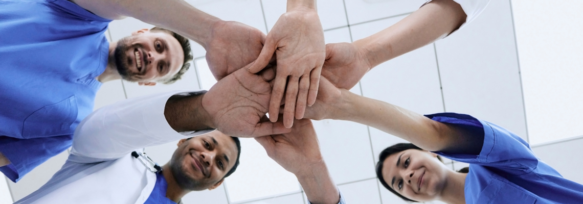 Abbildung ein Team legt die Hände in die Mitte 