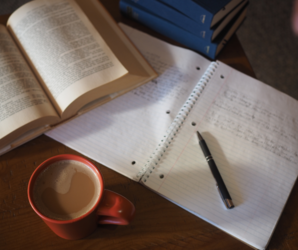 Abbildung Notizblock mit einen Stift, einen Buch und einem Kaffee