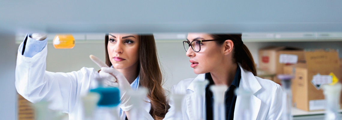 Abbildung Zwei Frauen in Laborkitteln führen ein Experiment im Labor durch 