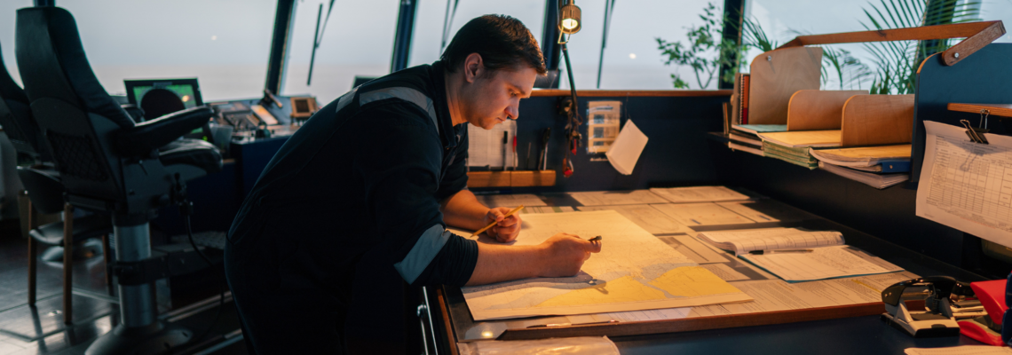 Abbildung Ein Mann steht in einer Schiffskabine und untersucht Karten 