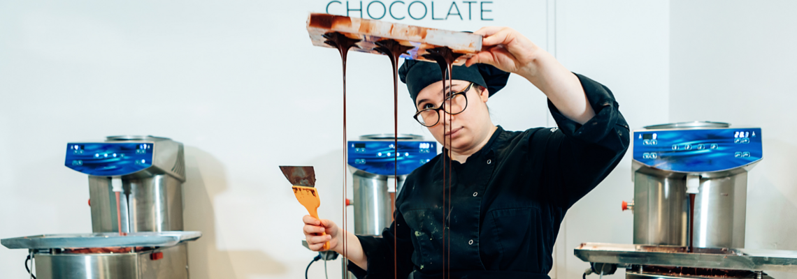 Abbildung Eine Frau in Kochkleidung macht Sterne aus Schokolade 