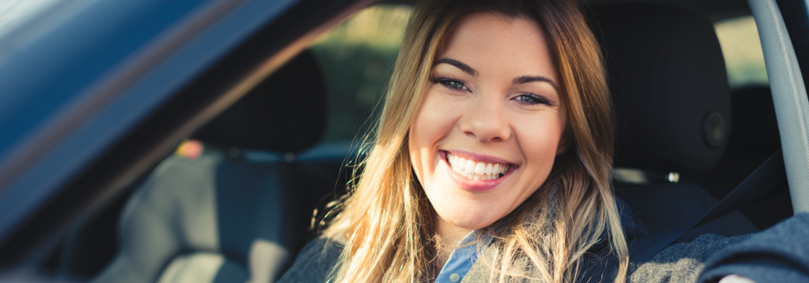 Abbildung Frau im Auto lächelt in die Kamera