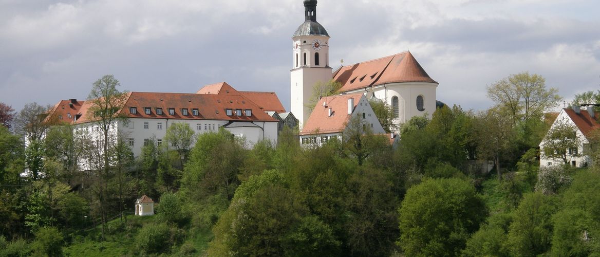 Abbildung auf einen Wiesenberg auf dem die Klosteranlage steht