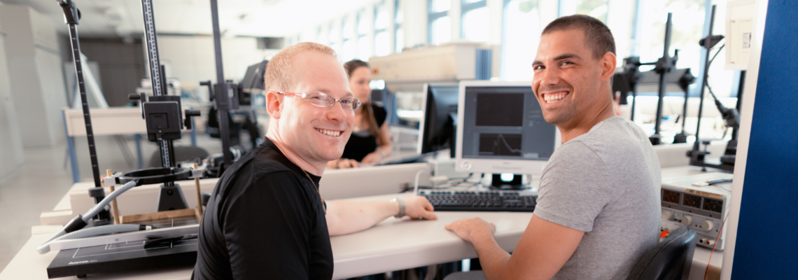 Abbildung Zwei Männer arbeiten an einem Computer mit einem Scanner
