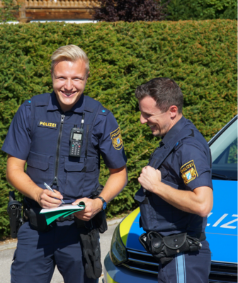 Abbildung zwei Polizisten machen sich Notizen auf einem Klemmbrett