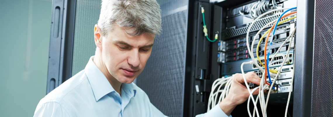 Abbildung Ein Mann überprüft Kabelverbindungen an einem Server 