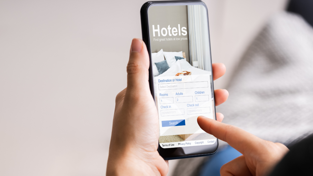 Abbildung Person bucht am Smartphone ein Hotel