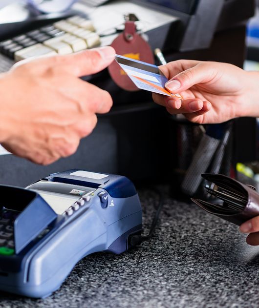 Abbildung eine Hand gibt einer anderen Hand eine Kreditkarte für ein Kartenlesegerät