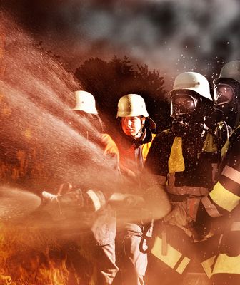 Abbildung Feuerwehrmänner löschen eine Brand mit Sand