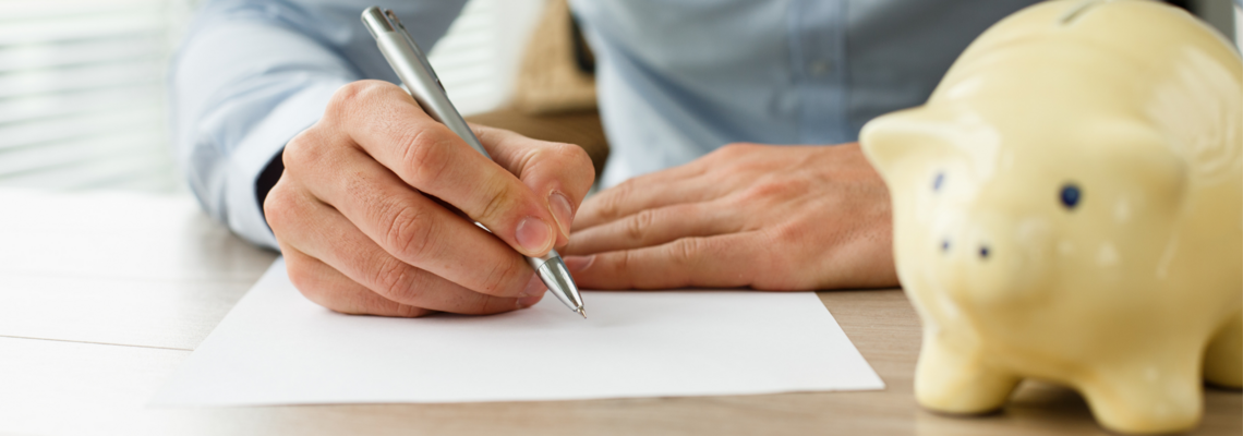 Abbildung Hände die mit einem Stift auf ein weißes Blatt schreiben und daneben steht ein gelbes Sparschwein