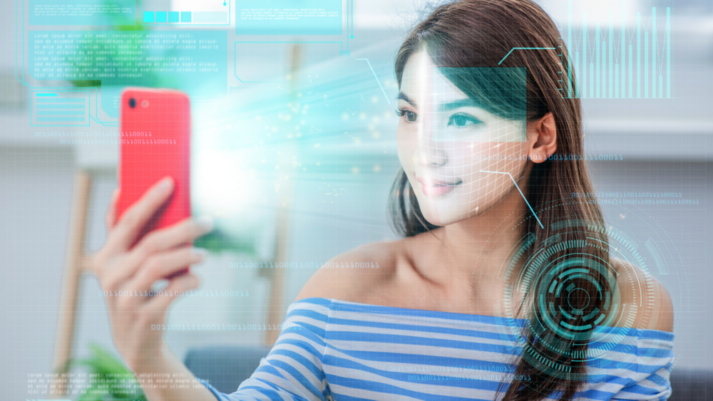 Abbildung Frau die ihr Handy vor Ihr Gesicht hält um eine Gesichtserkennung durchzuführen