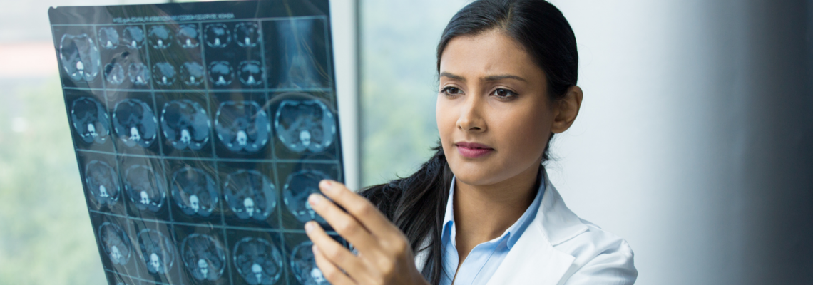 Abbildung eine Fachkinderkrankenpflegerin schaut sich Röntgenaufnahmen an