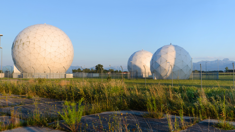 Abbildung Radomen des Bundesnachrichtendienstes auf grüner Wiese mit blauen Himmel im Hintergrund 