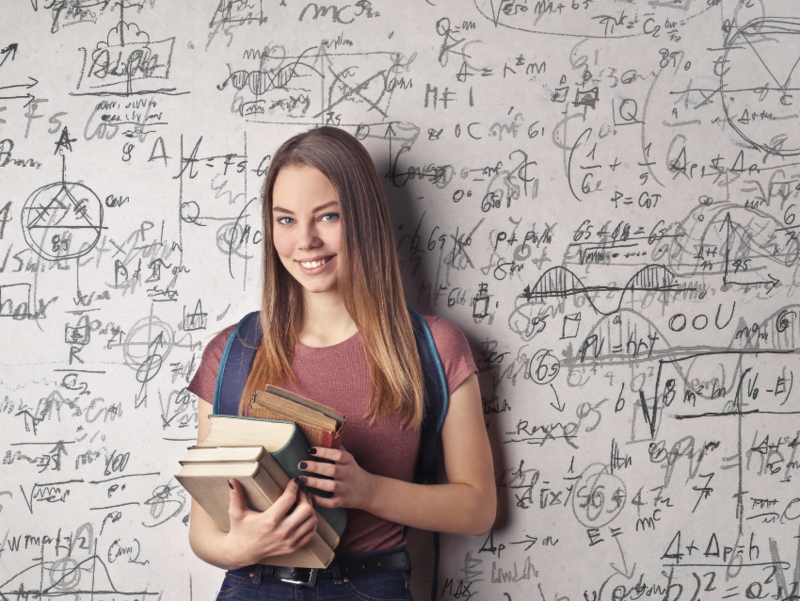 Abbildung Person steht vor einer Wand mit mathematischen Formeln