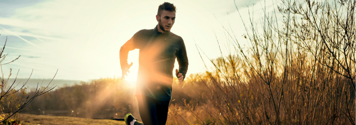 Abbildung ein Mann joggt bei Sonnenuntergang ein Feld entlang 