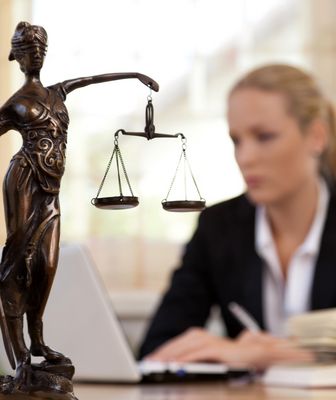 Abbildung Justizia und Frau vor einem Laptop