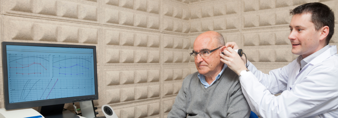Abbildung Ein junger Mann führt Untersuchungen im Ohr eines älteren Mannes 