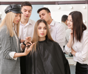 Abbildung 4 Personen stehe um eine Person herum die sich die Haare schneiden lässt