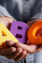 Abbildung Kinderhände die, die Buchstaben A, B und C halten