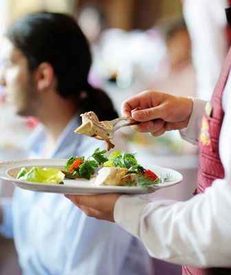 Abbildung Person serviert Essen auf einem Teller