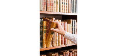 Abbildung eine Hand an einem Buchregal, die ein Buch herausnimmt