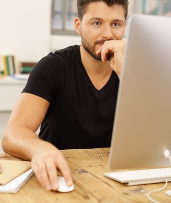 Abbildung Mann mit Tastatur und Maus vor einem Bildschirm