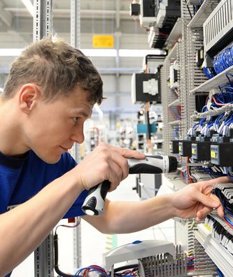 Abbildung junger Mann arbeitet an einer Elektroanlage