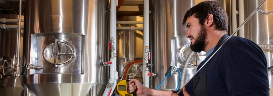 Abbildung ein Mann überprüft die Tanks in einer Brauerei
