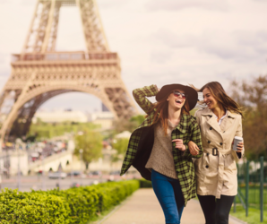 Abbildung zwei Personen gehen vor dem Eiffelturm